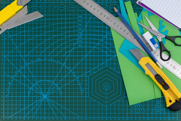 office supplies on green cutting mat board