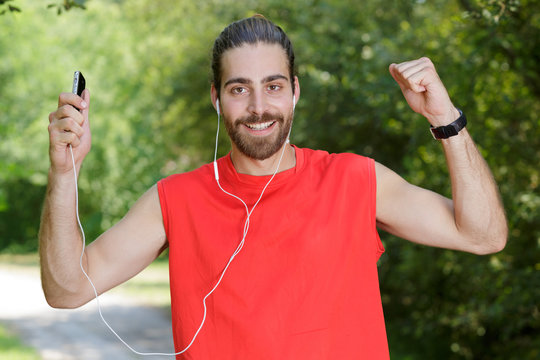 exicted man exercising and listening to music wearing earphones