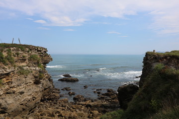 VISTA DEL MAR ENTRE LOS ACANTILADOS EN UN DÍA DESPEJADO CON EL HORIZONTE DE FONDO