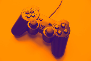 Joystick on orange background. Gamepad for playing computer games. © Vadym