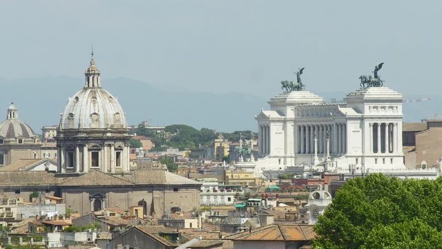 Medium low angle panoramic still shot of  Rome city skyline showing St. Andrea dome and Vittoriano Emmanuelle II Monument against blue sky, Rome, Italy