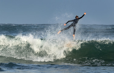 Mossel Bay, South Africa. Surfing the waves. Surfer riding wave,  storm sky 