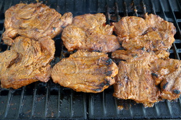 fresh stakes grilling on the gas barbecue