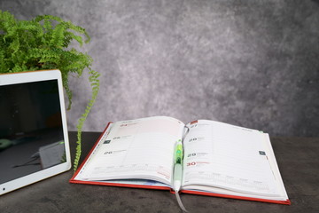Obraz premium top view Office working desk with Notepad and tablet and green flower