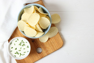 Potato chips and sauce on the table top view.