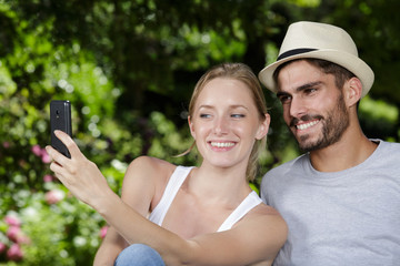 young couple taking selfie in the park