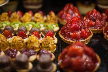 delicious street food and deserts in Istanbul city, Turkey. Chocolate tarts and strawberry shortcake pies. Fresh Fruit Tart with berries in display at a street food market
