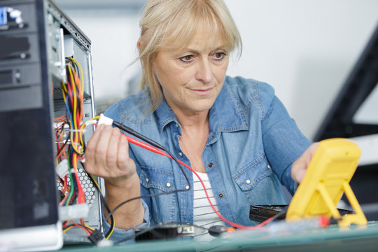 mature woman checking the currect of a pc