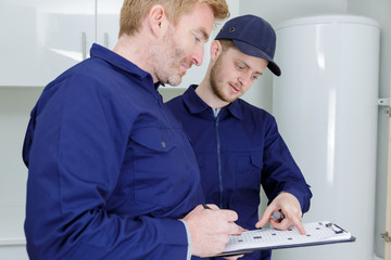 male plumber and apprentice working on boiler