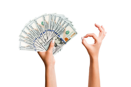 Isolated image of dollars in one hand and showing okay gesture with another hand. Top view of business concept