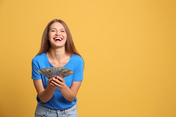 Fototapeta na wymiar Portrait of happy lottery winner with money on yellow background, space for text