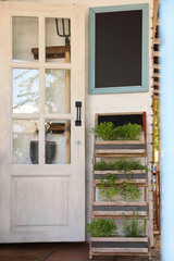 Wooden rack with home plants near shop outdoors