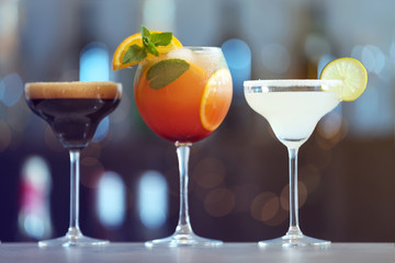 Row of different fresh alcoholic cocktails on bar counter