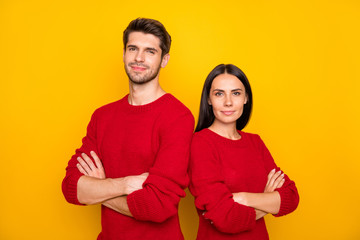 Obraz premium Portrait of focused man and woman with crossed hands stare wear red pullover isolated over yellow background