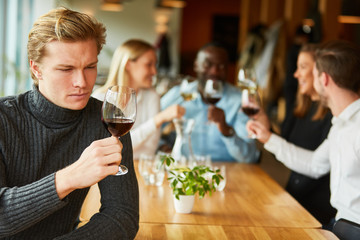 Junger Mann bei einer Weinprobe oder Verkostung