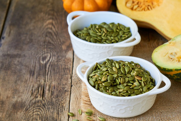 Peeled pumpkin seeds in white bowls 