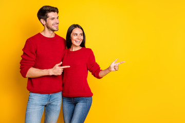 Profile side photo of two charming people point at copy space show promo wear red sweater denim jeans isolated over yellow background