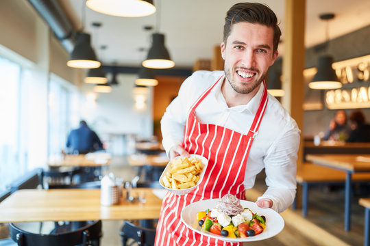 Kellner serviert einen Griechischen Salat