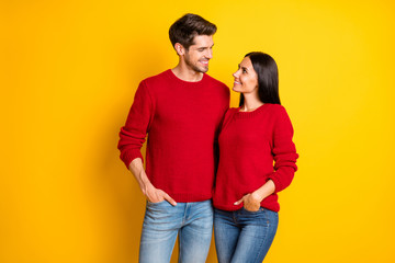 Portrait of charming spouses hug smile enjoy wear red jumper denim jeans stand isolated over yellow background