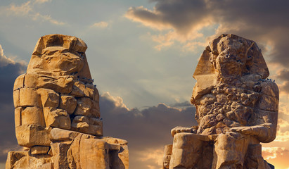 Colossi of Memnon Luxor Thebes against the background of dawn in the Egypt
