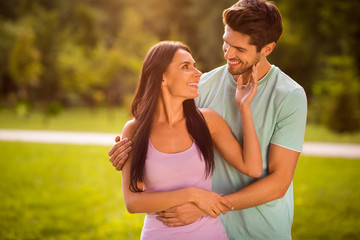 Portrait of lovely married two people piggyback wearing bright t-shirt outside in park