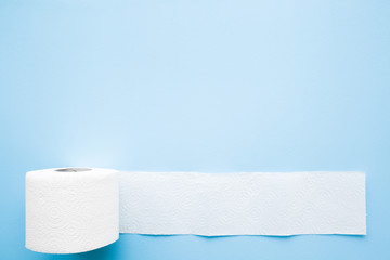 Soft, white toilet paper roll on light pastel blue background. Hygiene concept. Empty place for...