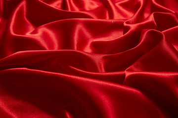Obraz premium Luxury red satin smooth fabric background for celebration, ceremony, event invitation card or advertising poster