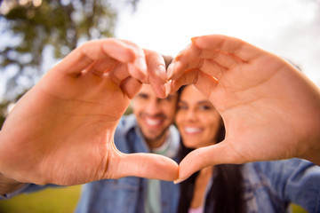 Close-up portrait of his he her she nice attractive lovely sweet cheerful cheery married spouses showing heart frame shape perfect match soulmate life partner in green wood forest
