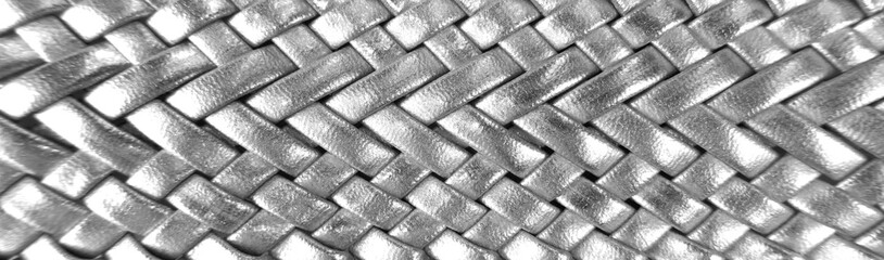 Silver-colored braided leather belt.   Metallic shiny.   Detail, texture, close-up