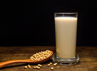 soy milk with beans on black background
