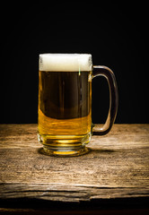 glass of beer on wooden background