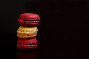 Macaroons isolated on black background. Image contains copy space
