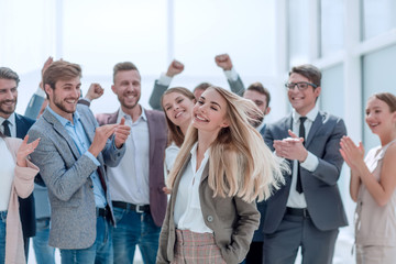 Obraz premium happy young woman standing in front of her jubilant colleagues