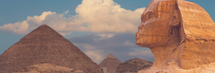Sphinx against the backdrop of the great Egyptian pyramids. Africa, Giza Plateau.	