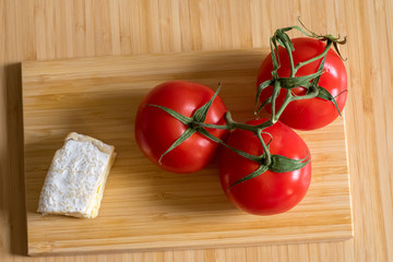 Still life with three tomatoes and cheese camambert