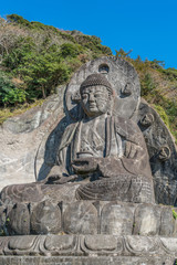 Fototapeta na wymiar Mount Nokogiri (Nokogiriyama) Great Buddha (Nihon-ji daibutsu). Carving of seated sculpture of Yakushi Nyorai completed in 1783. The largest pre-modern stone-carved Daibutsu in Japan