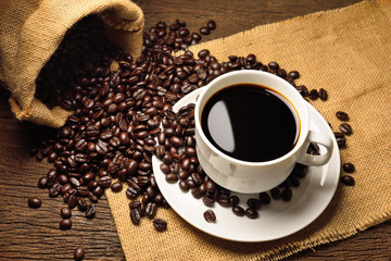 cup of coffee and beans on wooden background