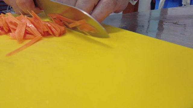 Chef sta tagliando delle carote per una cena in un ristorante.