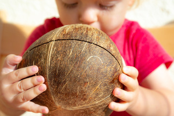 Young toodler is drinking fresh organic coconut water with a straw