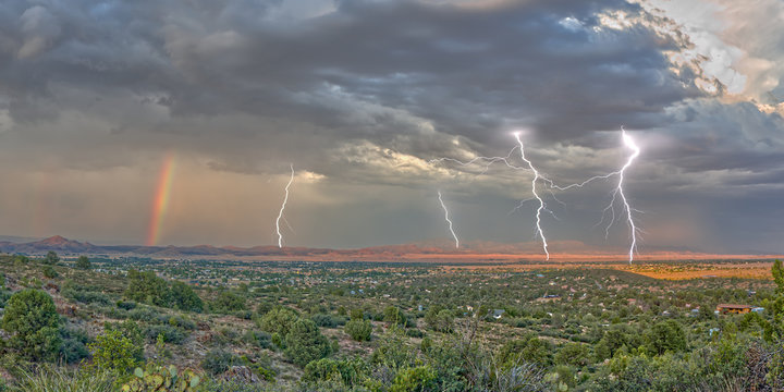 A lightning storm with a rainbow rolling over Mingus Mountain just east of Chino Valley, Arizona