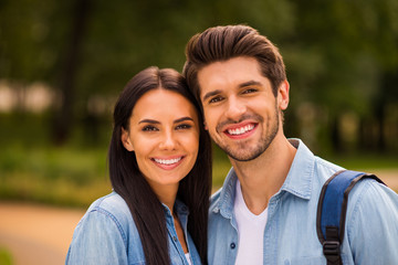 Photo of overjoyed pair standing together in green summer park wear denim outfit