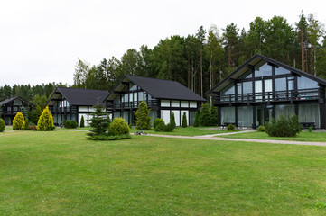 Fototapeta na wymiar Scandinavian-style cottage village in the woods and gardens