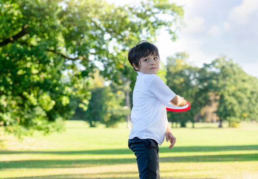 Portrait of school boy have fun with flying disc in the park, Sport and recreation  for children concept