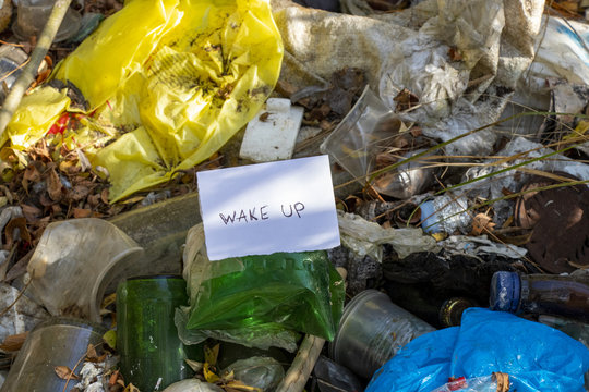 Words written with a pen on a white sheet of paper stating awakening in English on a pile of garbage in a forest in Ukraine