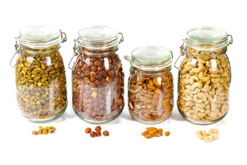 nuts in glass jars isolated on white