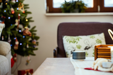 Fototapeta na wymiar Smart ai speaker. Smart home concept with christmas tree in background
