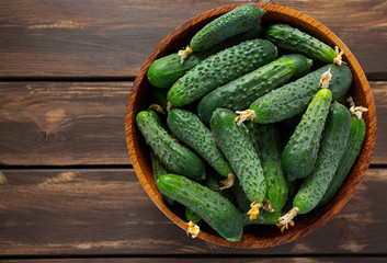 cucumbers in a bowl on wooden surface