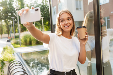 Business lady with cup of coffee take selfie by mobile phone.