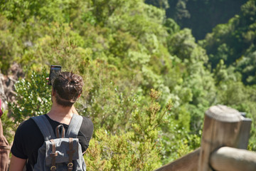 Young man takes a photo of the mountain