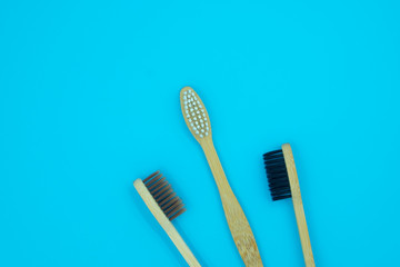 Wooden bamboo toothbrushes isolated on blue background. Concept dental eco-friendly...